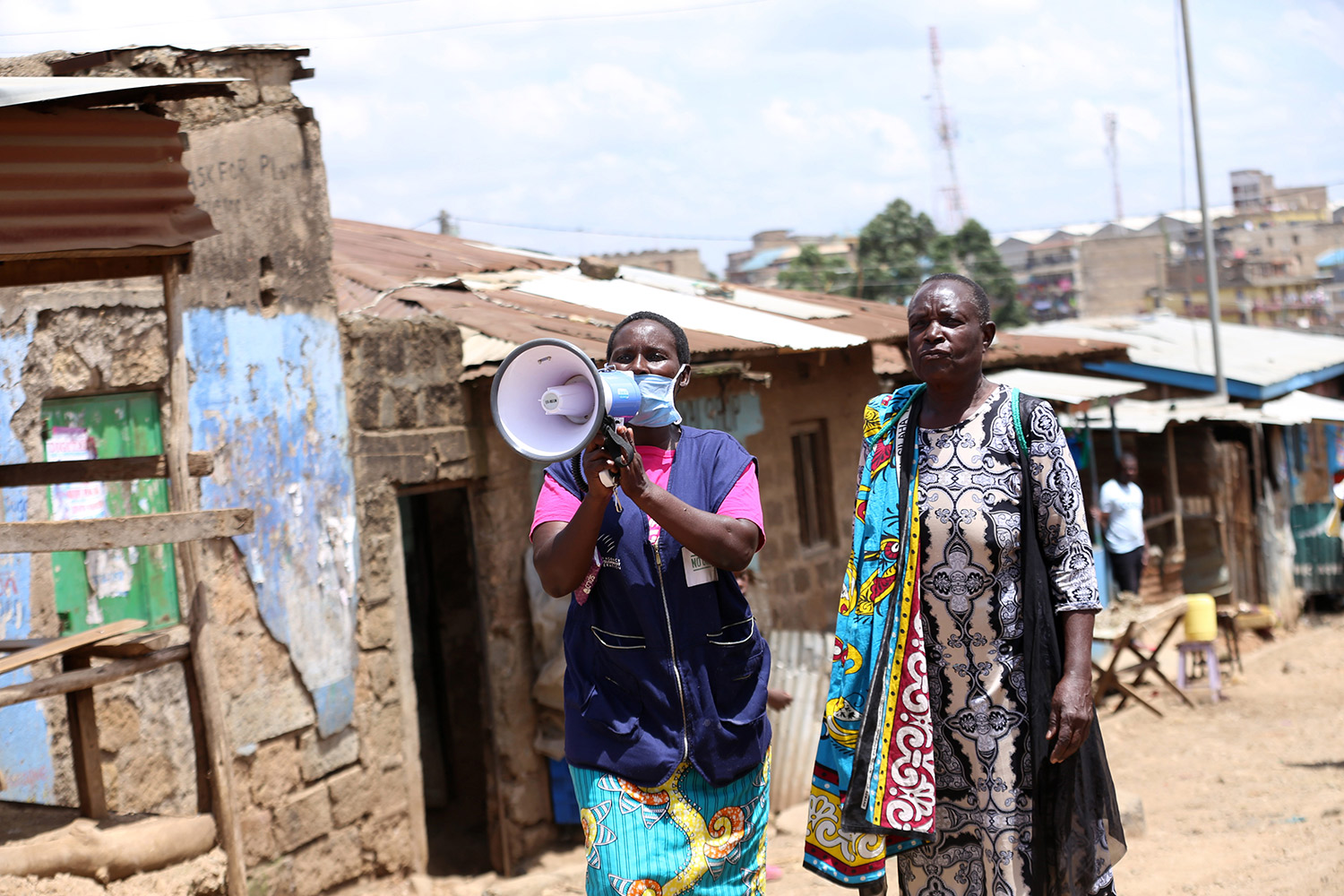 Una voluntaria sanitaria sensibiliza con un megáfono a los residentes sobre el coronavirus en el slum de Babadogo, en Nairobi (Kenia)