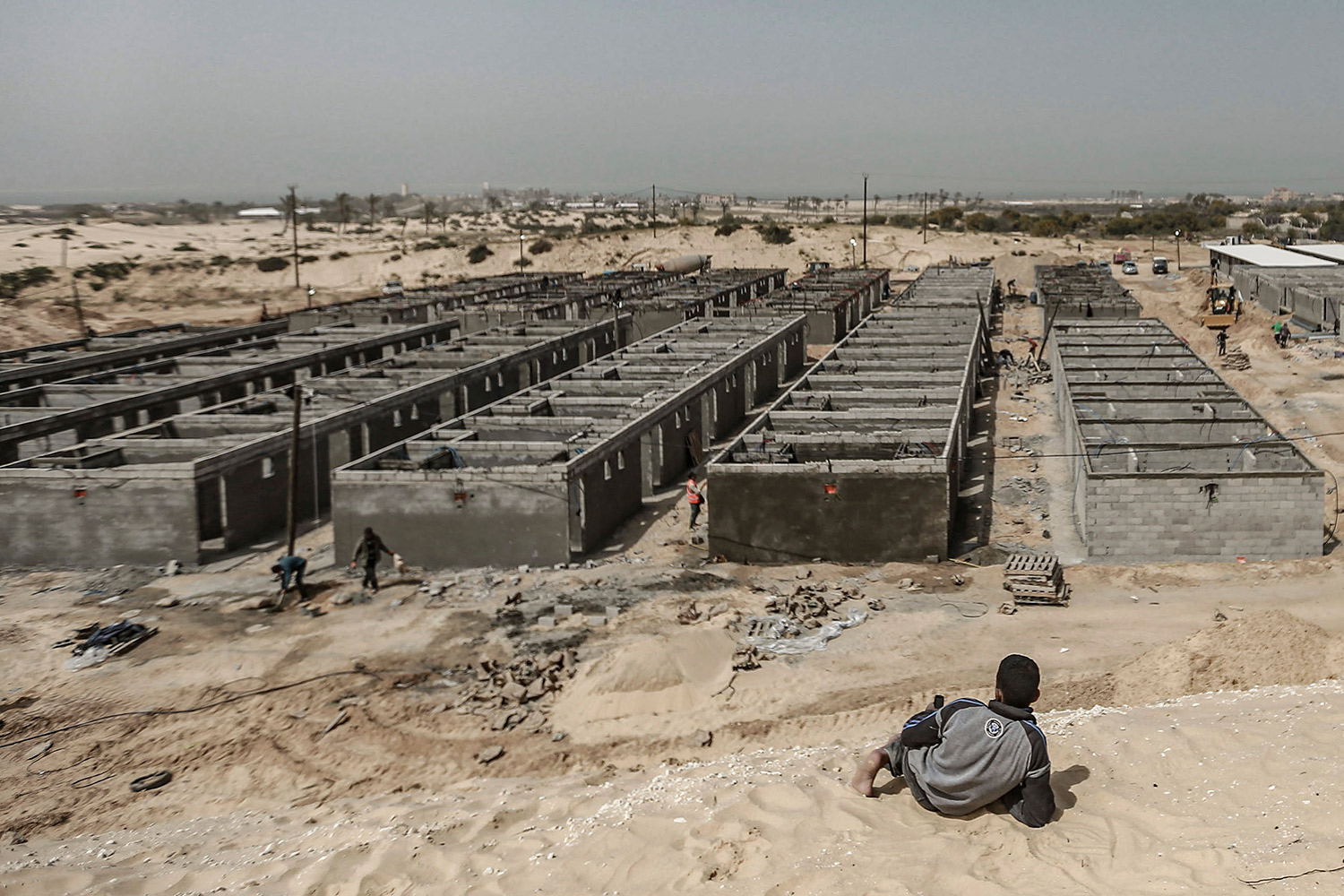 Un trabajador de la construcción descansa cerca del lugar donde construyen un hospital de campaña creado por Hamas para alojar pacientes con coronavirus