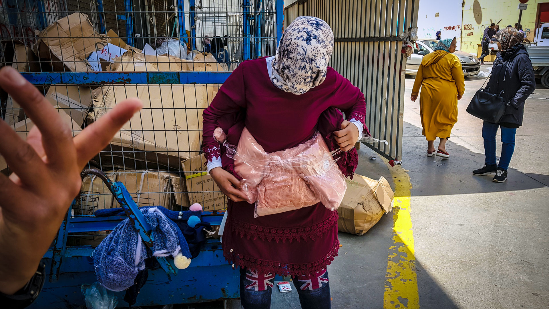 Una mujer porteadora embala mercancía alrededor de su cuerpo para camuflarla