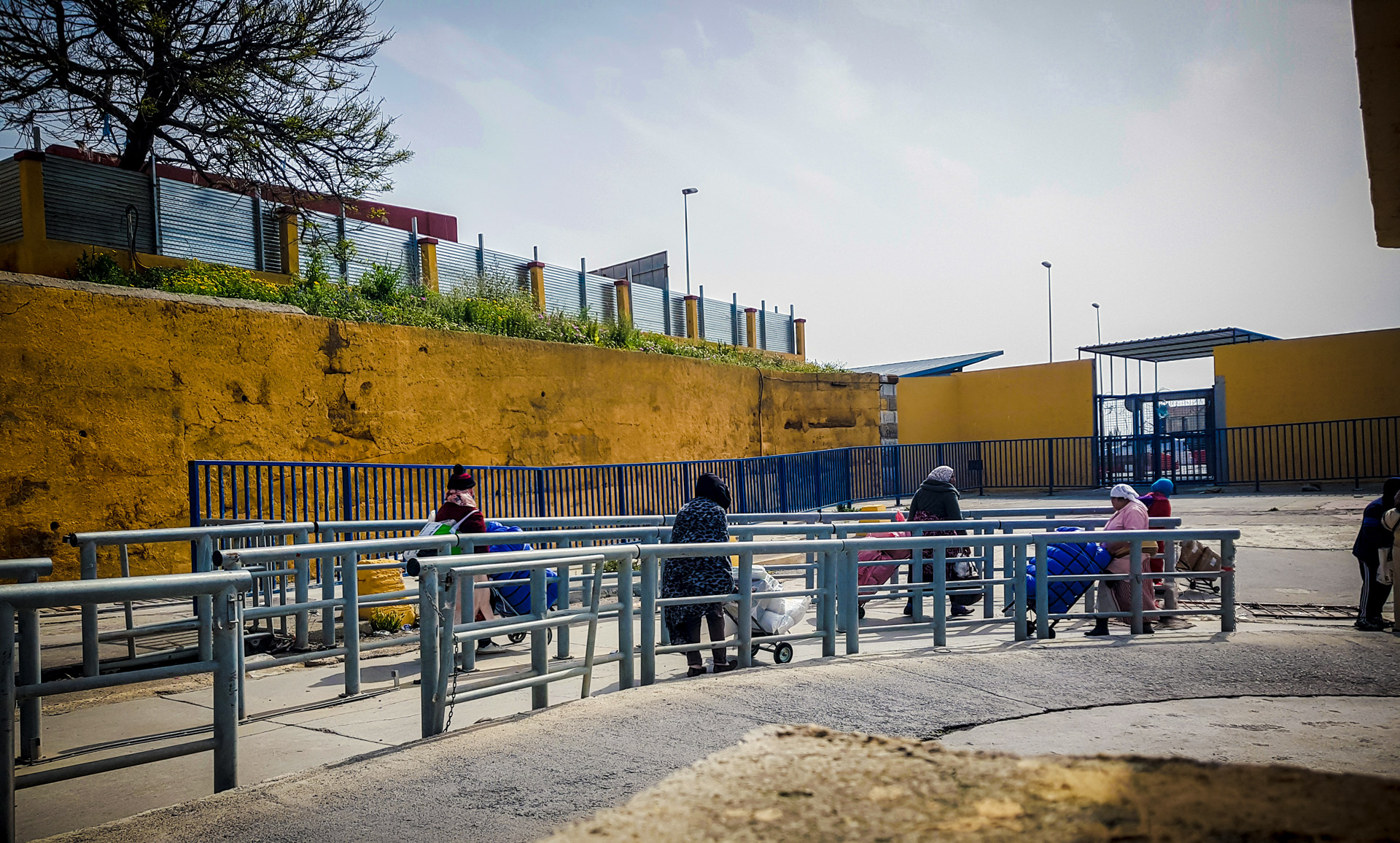 Mujeres portean, invisibilizadas tras un muro en la frontera